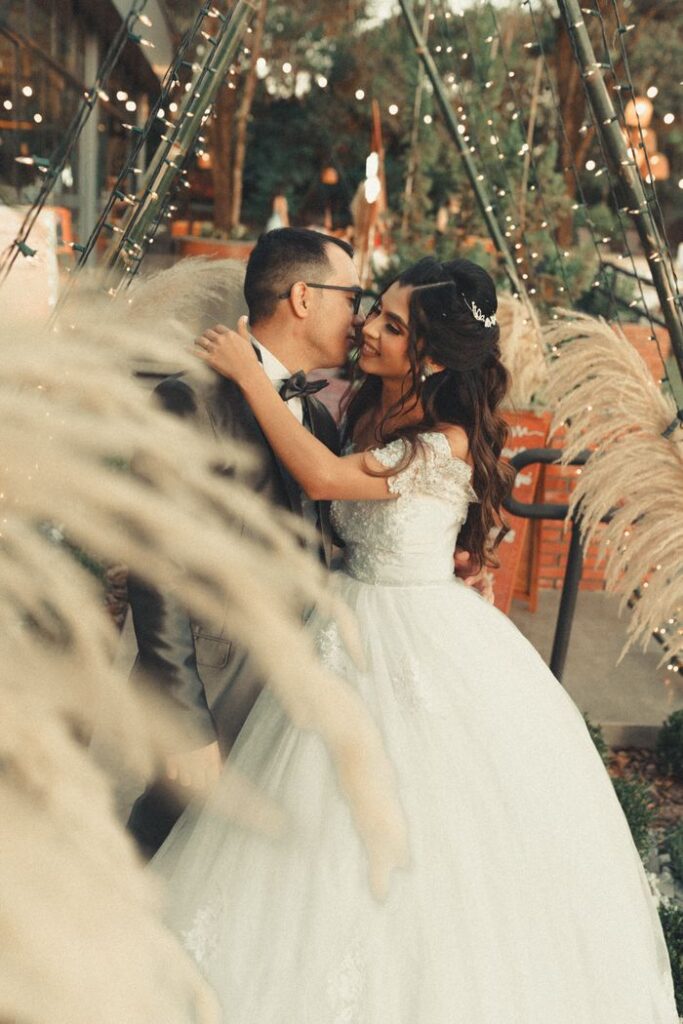 Crafting Captivating Headlines: Your awesome post title goes here Bride and groom sharing a romantic moment in a beautifully decorated outdoor setting.