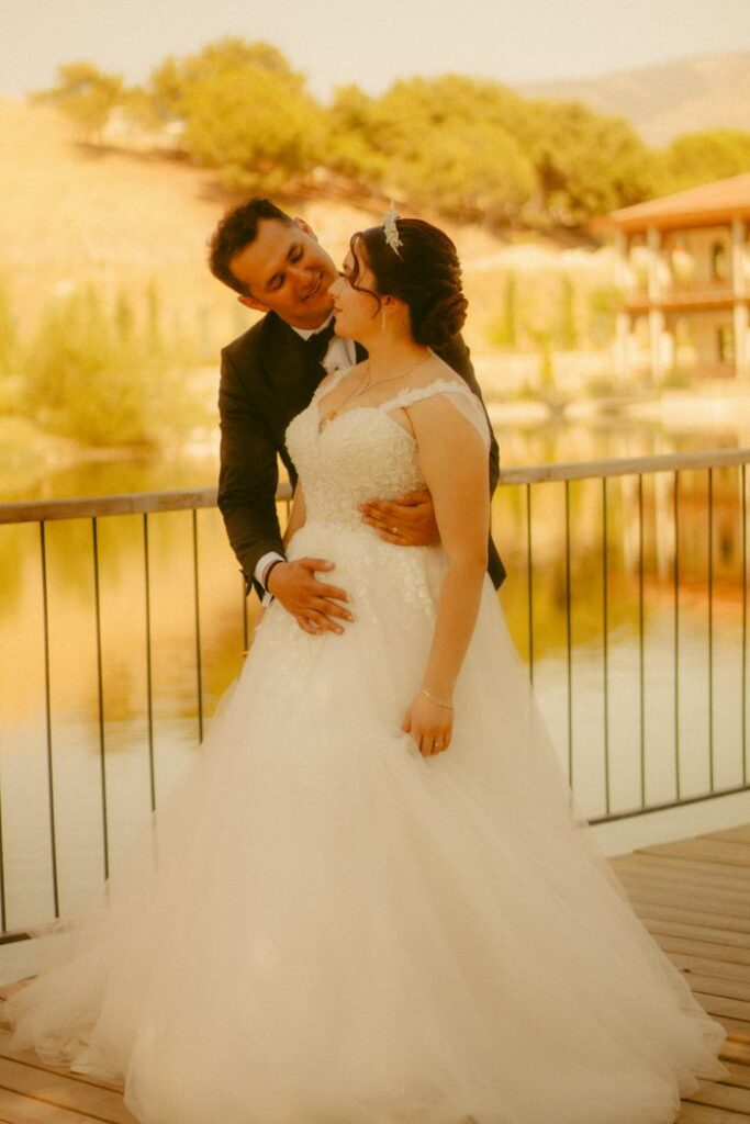 The Art of Drawing Readers In: Your attractive post title goes here Bride and groom embracing on a scenic lakeside deck, perfect wedding day.